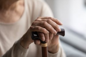 Elderly person holding a walking stick