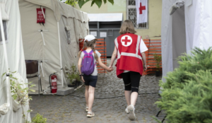 A Red Cross worker accompanies a child at the Red Cross Health Centre in Uzhhorod, Eastern Ukraine